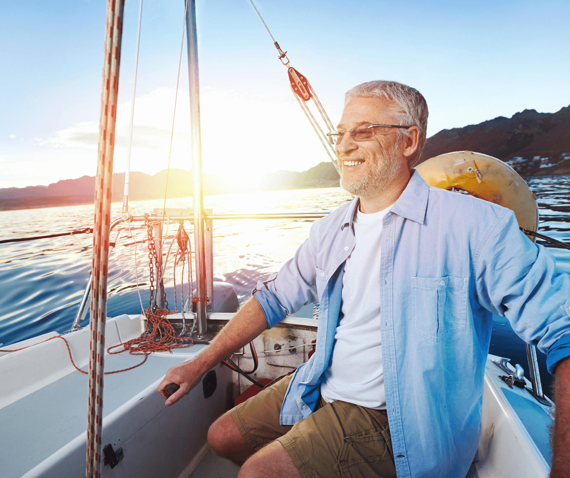 man steering a boat in the sunset